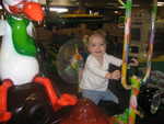 Madison riding the machines at Chuck-E-Cheese