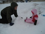 Chelsea and Madison building a chair out of snow for Madison to sit on