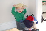Madison sitting in Grandma Newsome's hat basket and playing dress ups