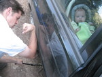 Jordan changing a flat tire at the Smith family camp out - Madison showing moral support