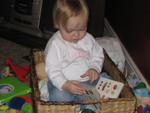 Madison emptied out her toy basked and climbed in to read a book